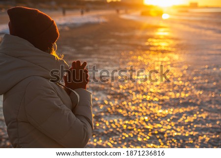 Young woman winter enjoying winter sun. Red sunset light. Winter solstice.
