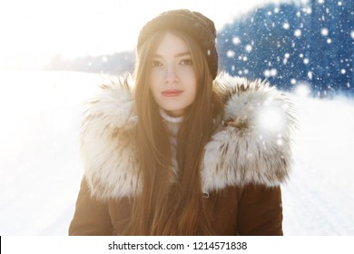 Young woman at winter. Portrait of a happy teenage girl in the snow.