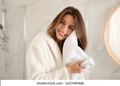 Young Woman Wiping Face With Towel In Bathroom