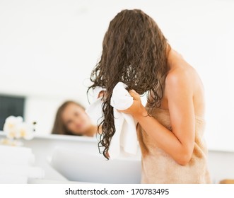 Young Woman Wiping Hair With Towel. Rear View