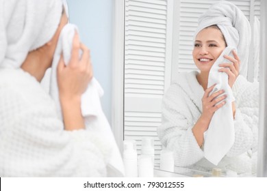 Young Woman Wiping Her Face With Towel In Bathroom