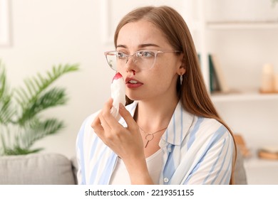 Young Woman Wiping Nosebleed With Tissue At Home, Closeup