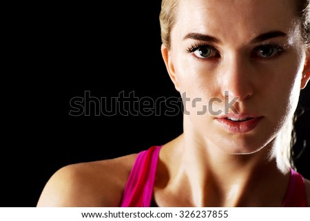 Similar – Close up front portrait of one young athletic woman in sportswear in gym over dark background, standing in boxing stance with hands and fists, looking at camera