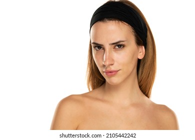 young woman without makeup looking  with distrust on a white background