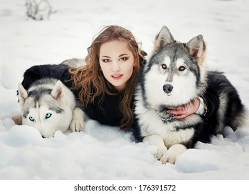 Young Woman With Wolf Dog In Snow