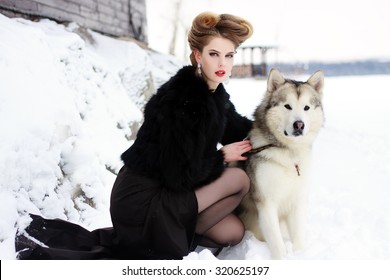 Young Woman With Wolf Dog In Snow