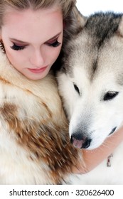 Young Woman With Wolf Dog In Snow