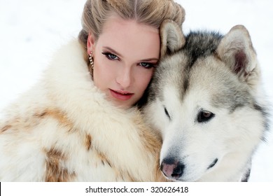 Young Woman With Wolf Dog In Snow