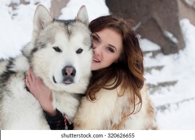 Young Woman With Wolf Dog In Snow