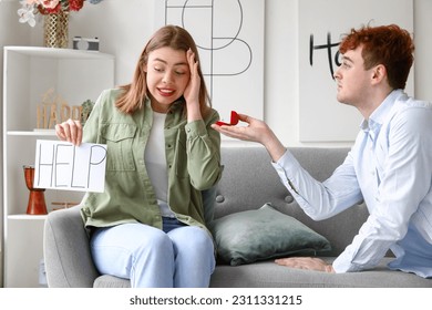 Young woman with word HELP get proposed at home - Shutterstock ID 2311331215