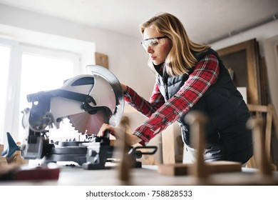 Young Woman Worker In The Carpenter Workroom.