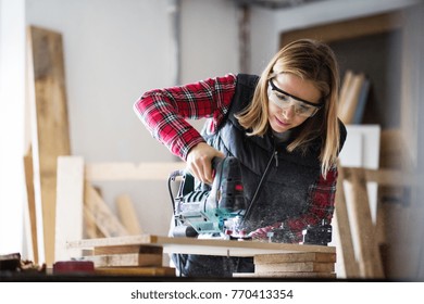 Young Woman Worker In The Carpenter Workroom.