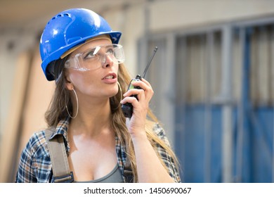 young woman worker using radio communication device
