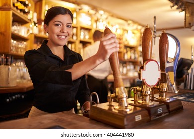 A Young Woman Working Behind A Bar Looking To Camera, Horizontal