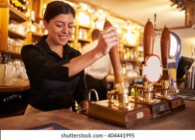 A Young Woman Working Behind A Bar Preparing Drinks