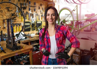 Young woman working in a bicycle repair shop - Powered by Shutterstock