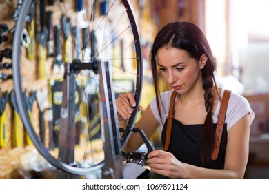 Young Woman Working In A Bicycle Repair Shop