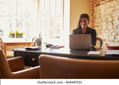 Young Woman Working At The Check-in Desk Of A Boutique Hotel