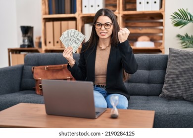 Young Woman Working At Consultation Office Holding Money Annoyed And Frustrated Shouting With Anger, Yelling Crazy With Anger And Hand Raised 