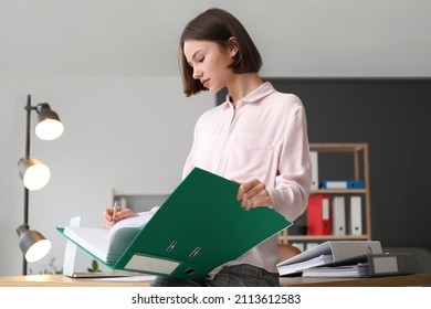 Young woman working with documents in office - Shutterstock ID 2113612583