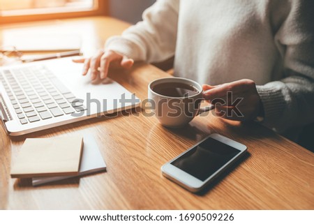 Young woman working in a home office on her laptop computer. Remote work concept.