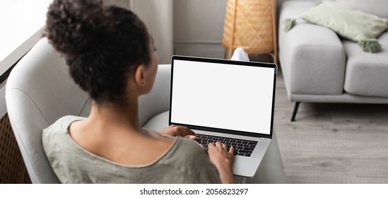 Young woman working at home, student girl using laptop computer with blank white empty screen monitor mock up. Online shopping, web site, working from home, online learning, studying concept.