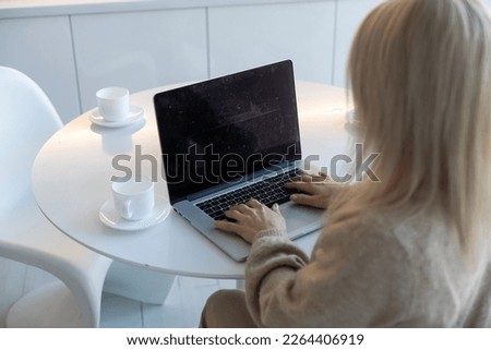 young woman working from home using computer, at home workplace using technology.