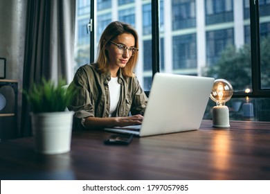 Young Woman Working With A Laptop. Female Freelancer Connecting To Internet Via Computer. Blogger Or Journalist Writing New Article.