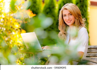 Young Woman Working With Laptop In Garden