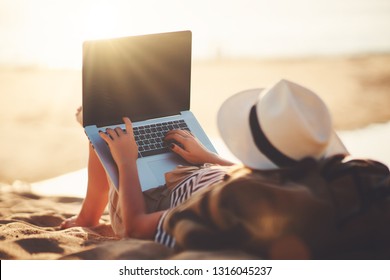 Young Woman Working With A Laptop On Nature In Summer Beach
