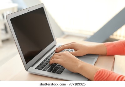 Junge Frau, die mit Laptop am Tisch arbeitet, Nahaufnahme