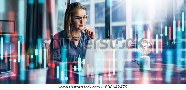 Young\
woman working at modern office.Technical price graph and indicator,\
red and green candlestick chart and stock trading computer screen\
background. Double exposure. Trader analyzing\
data