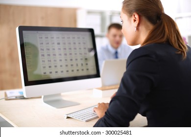 Junge Frau, die im Büro arbeitet, am Schreibtisch sitzt, Laptop benutzt