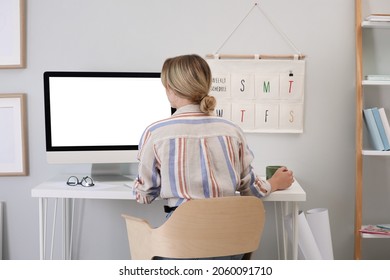 Young woman working on computer at table in room
