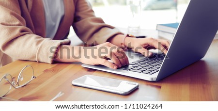 Young woman working on computer at table in office, closeup. Banner design
