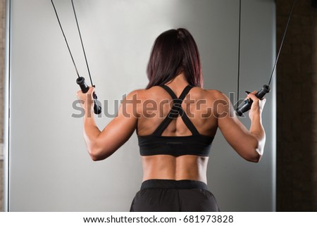 Similar – Rear view portrait of one young athletic woman at crossfit training, exercising with trx suspension fitness straps over dark background