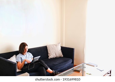 Young woman working on sofa