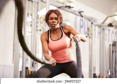 Young Woman Working Out With Battle Ropes At A Gym