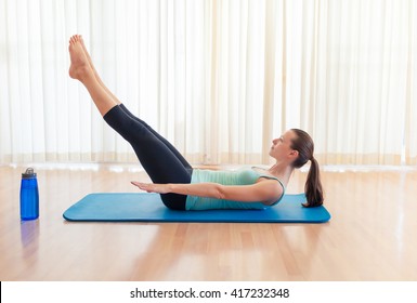 Young Woman Working Out Her Abs. Leg Lift Sit-up.