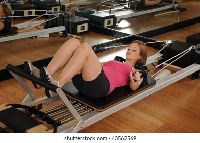 Young Woman Working Out On A Pilates Machine