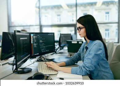 Young Woman Working And Programming On Computer In Office. Beautiful Female Programmer Working Looking At Monitor, Typing Data Code In Company Office. High Quality Image.