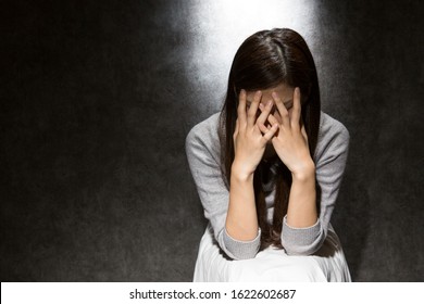 Young woman worried covering her face.
