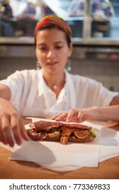 Young Woman Wrapping A Sandwich At A Deli Counter, Vertical