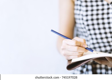 Young Woman Writer Wearing Black And White Dress, Is Writing Important Content Idea On Notebook, Note, Laptop With Pencil. Remind Schedule Memory Before Meeting With Coworker. Content Concept  