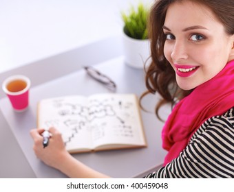 Young Woman Writes To Diary On A White Table