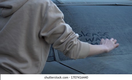 A Young Woman Writes With A Finger On A Dirty Car 