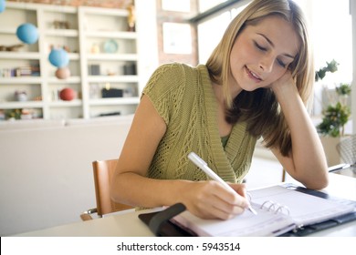 A Young Woman Writing In Her Agenda