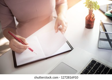 Young Woman Writing On Notebook At Home.