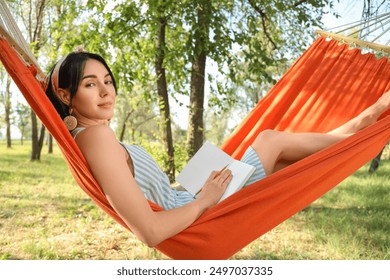 Young woman writing on notebook in hammock outdoors - Powered by Shutterstock