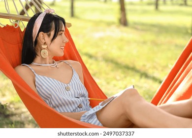 Young woman writing on notebook in hammock outdoors - Powered by Shutterstock